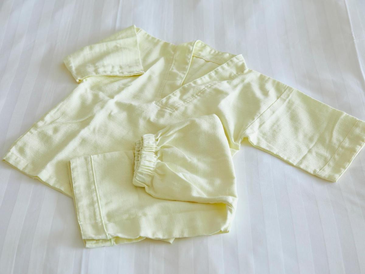 Grand Nikko Tokyo Bay Maihama Otel Urayasu Dış mekan fotoğraf The photo shows a small, traditional outfit made of light yellow fabric. The outfit includes a short-sleeved top with a V-neck and a pair of matching pants. The design is simple, featuring a loose fit and a comfortable style, making it suitable for c