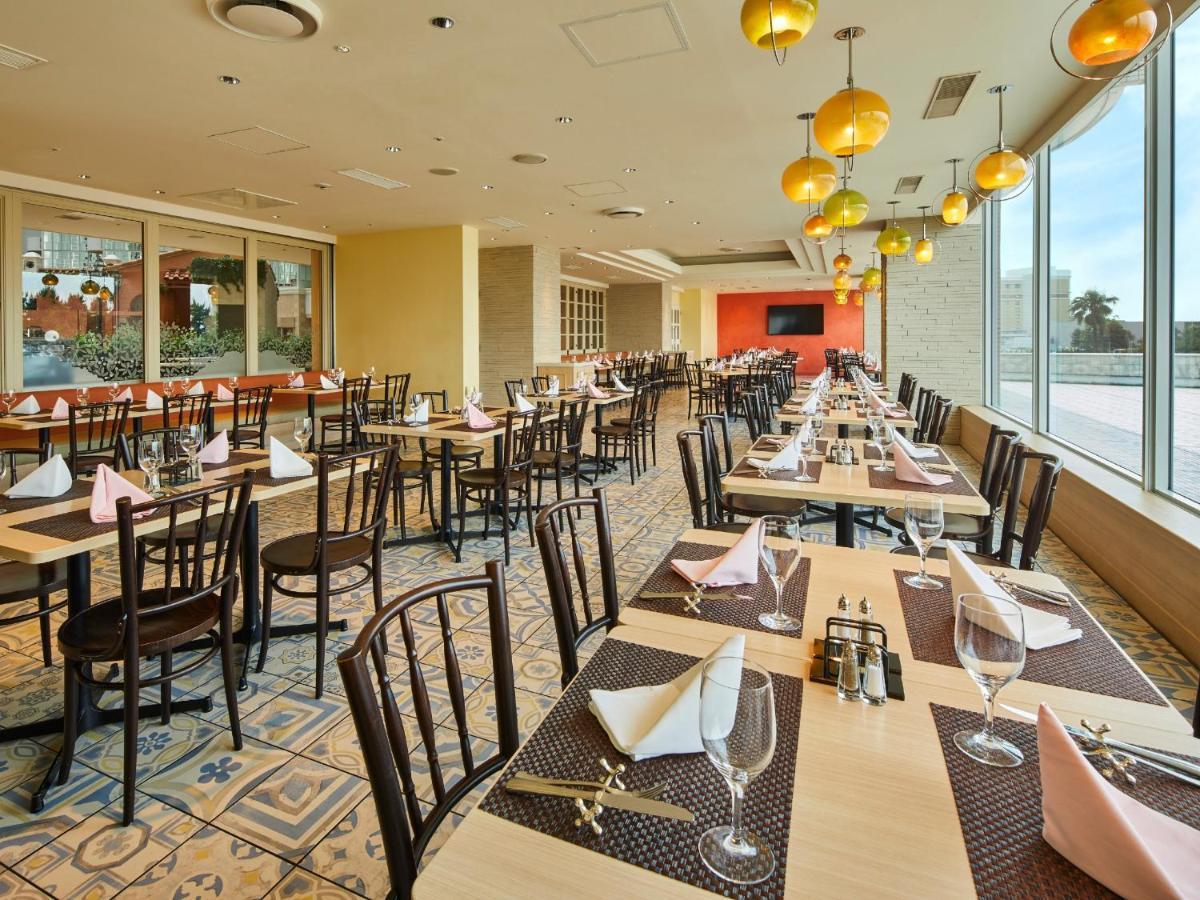 Grand Nikko Tokyo Bay Maihama Otel Urayasu Dış mekan fotoğraf The photo shows a spacious restaurant interior with multiple wooden tables arranged neatly. Each table is set with plates, glasses, and folded napkins, suggesting it's prepared for dining. The decor features large windows allowing natural light to fl