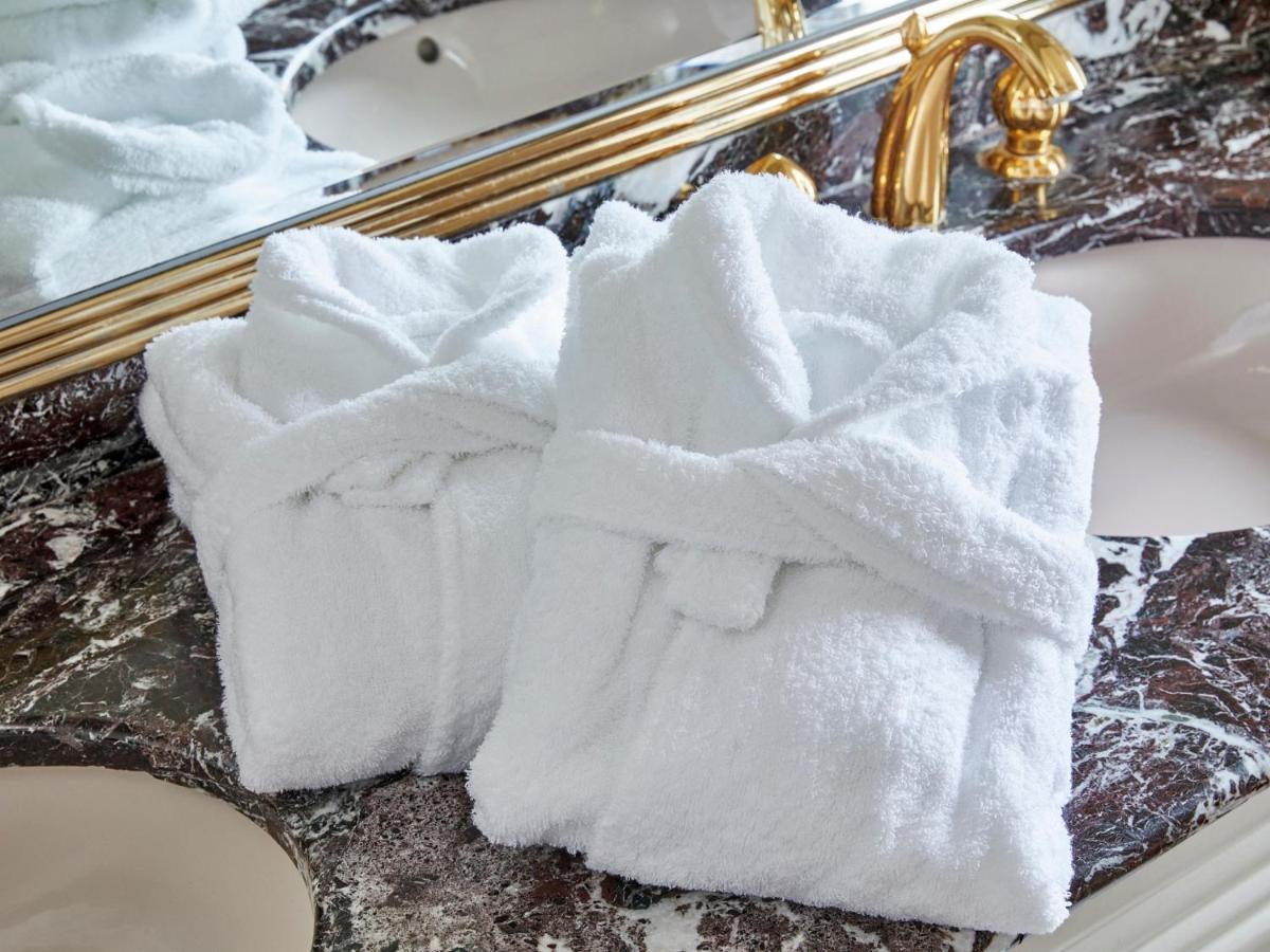Grand Nikko Tokyo Bay Maihama Otel Urayasu Dış mekan fotoğraf The photo shows two white bathrobes neatly folded and placed on a marble surface, likely in a luxurious bathroom setting. The bathrobes have a simple, classic design with belts tied around them. In the background, there appears to be a decorative mir