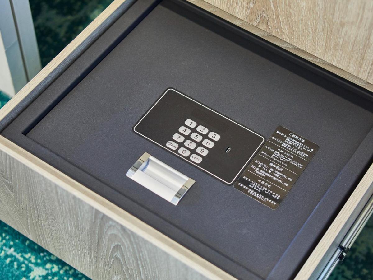Grand Nikko Tokyo Bay Maihama Otel Urayasu Dış mekan fotoğraf The photo shows a small safe that is installed in a drawer. Inside the safe, there is a digital keypad with numeric buttons for entering a code. Next to the keypad, there appears to be a small manual or instruction card. The interior of the safe is l