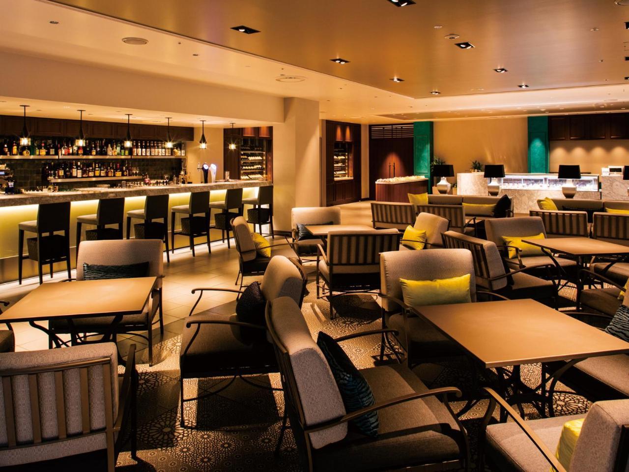 Grand Nikko Tokyo Bay Maihama Otel Urayasu Dış mekan fotoğraf The photo shows a modern, upscale lounge or bar area. It features a variety of seating options, including cushioned chairs and tables arranged for conversation. The space is well-lit, with warm lighting that creates an inviting atmosphere. In the bac